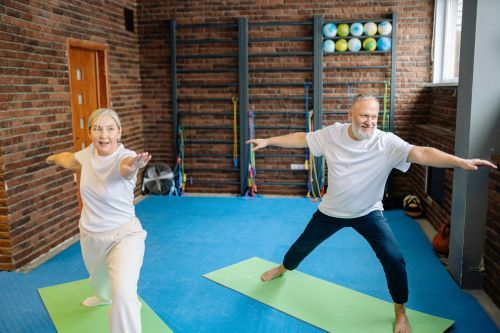 Two seniors in a yoga warrior pose