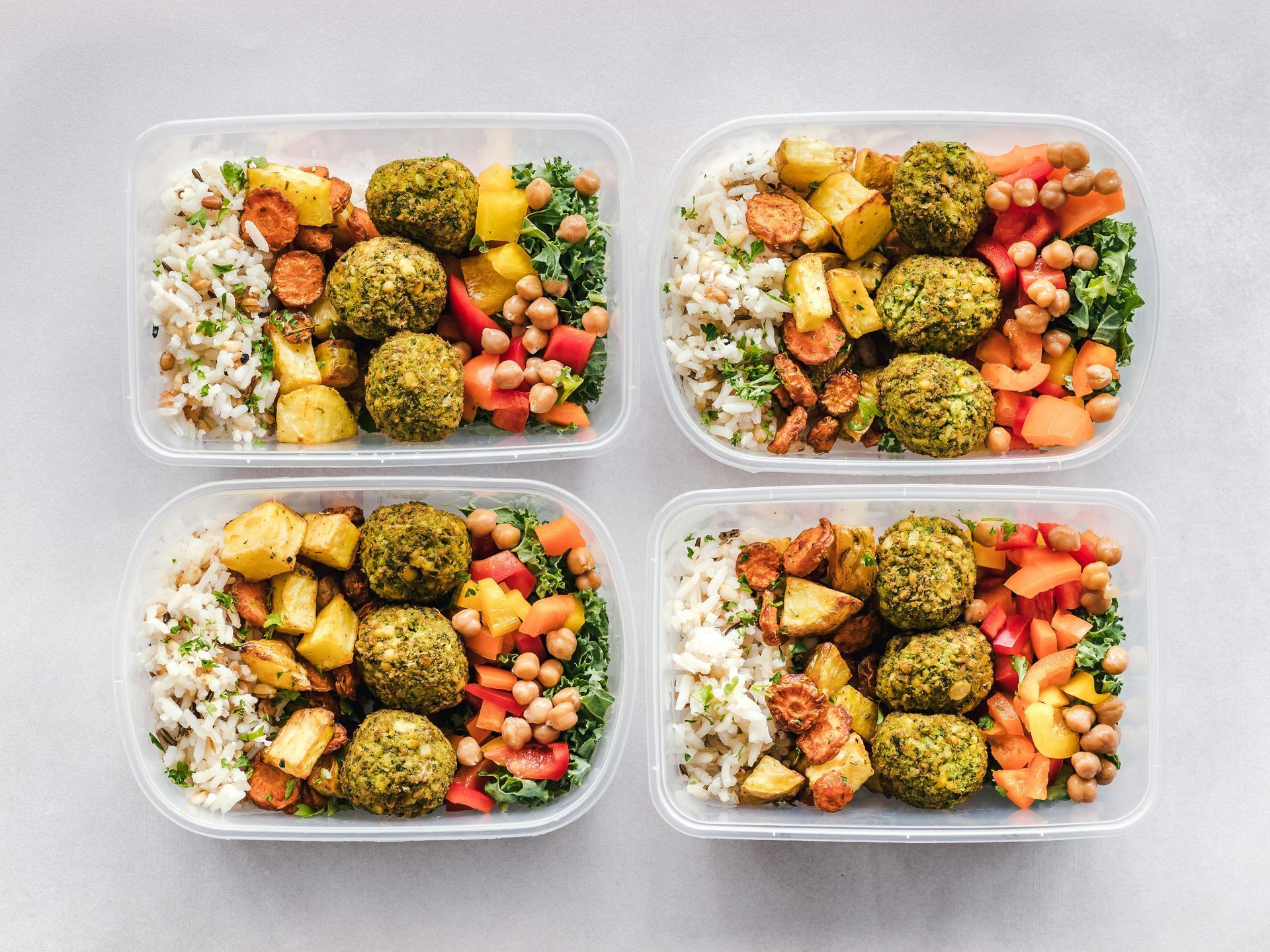 Four meal prep containers filled with nutritious food
