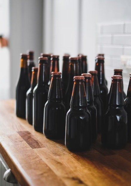Empty organic beer bottles on a wooden bench.