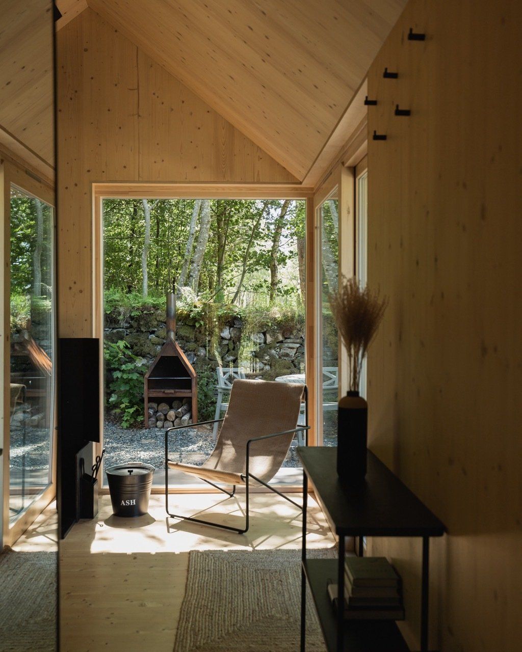 Award winning interior design of a luxury modern cabin in nature with trees behind.