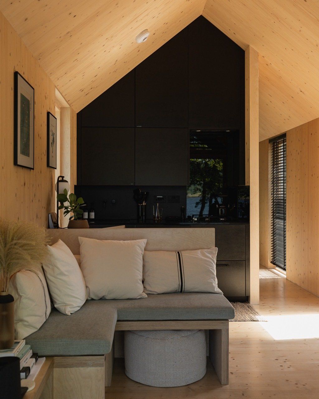 Sofa in a cool architect designed cabin black modern kitchen lots of natural light.