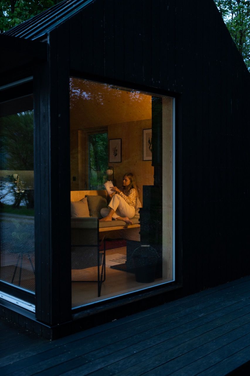 Female reading a book on sofa inside a luxury cabin.