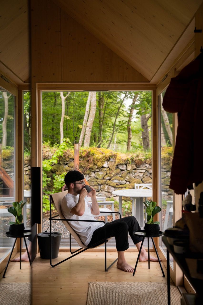 A man sipping a coffee inside a luxury cabin.