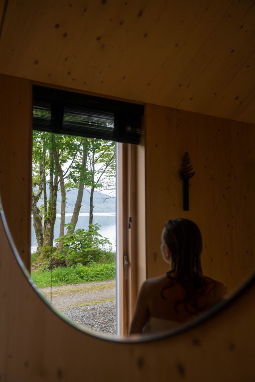 Female looking out to loch from luxury cabin.