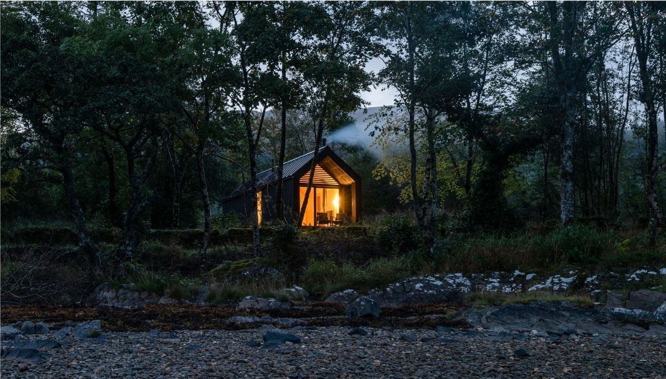Kabn Company cabins surrounded by trees  in the Evening.