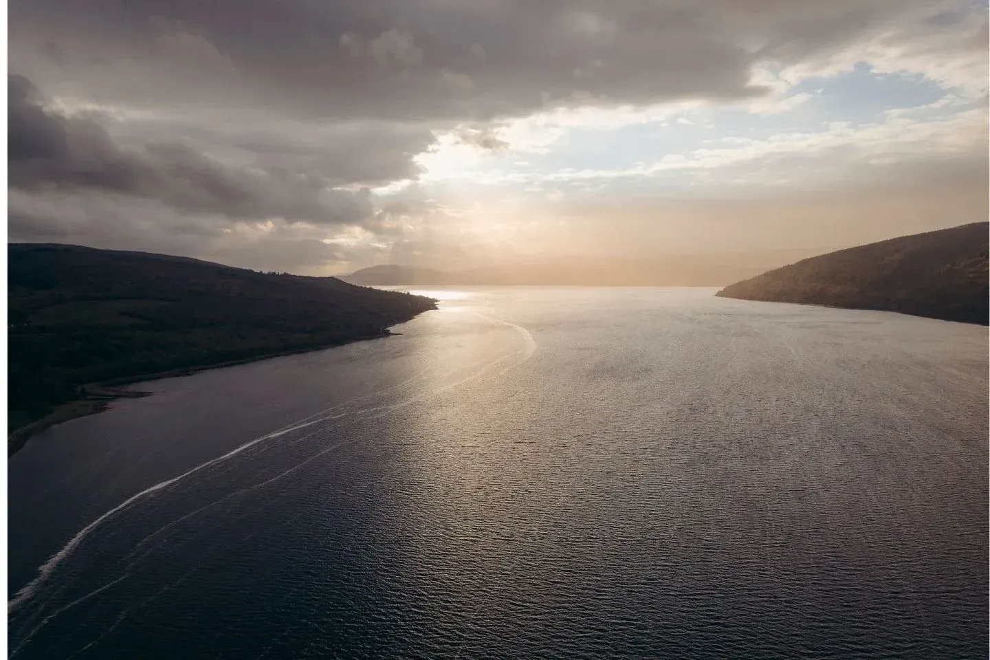 Sunset aerial view over Loch Fyne, Scotland, showing the vast water and surrounding hills at golden hour.
