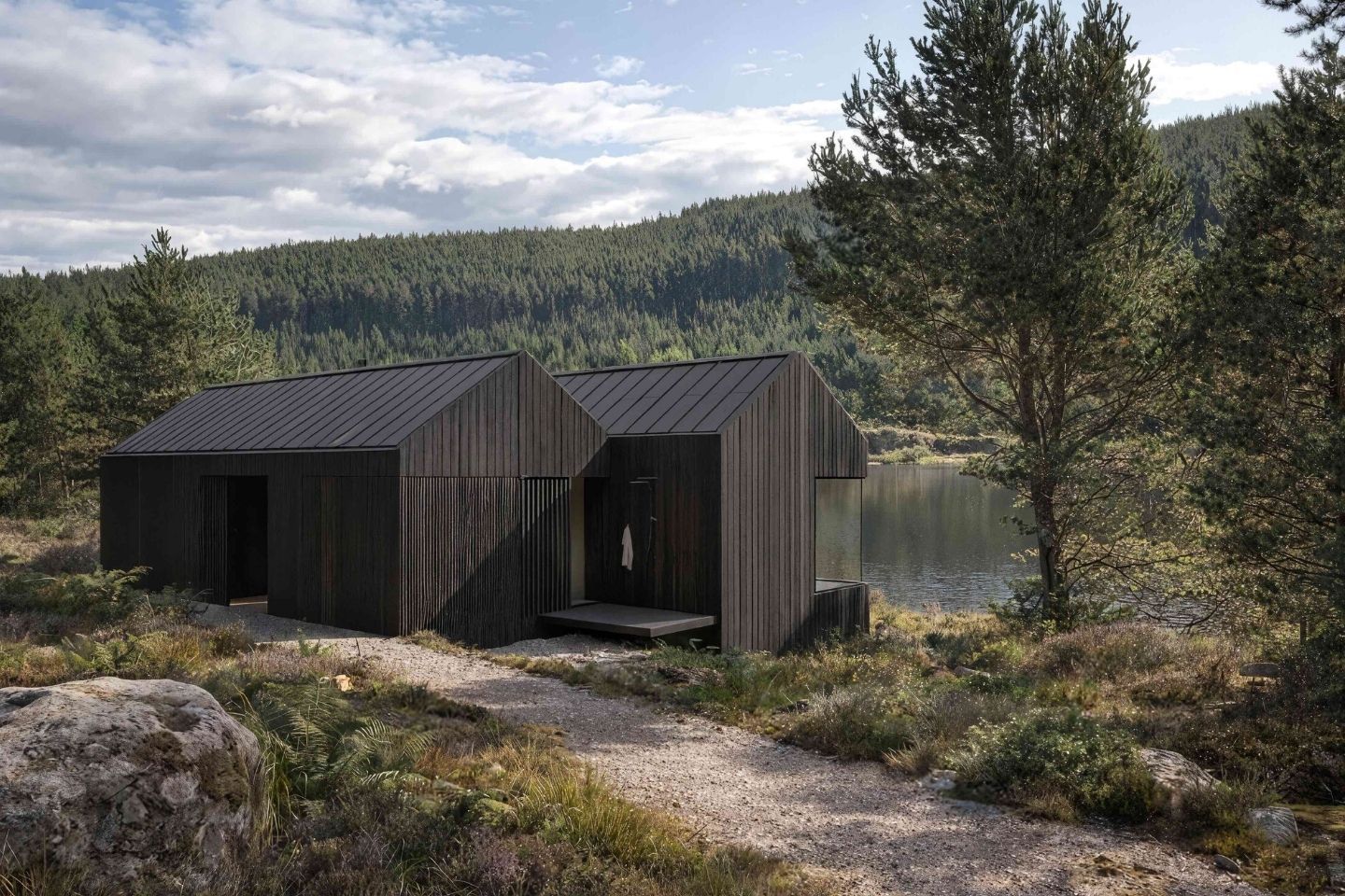 Luxury black timber cabins overlooking a loch in the Cairngorms National Park Scotland