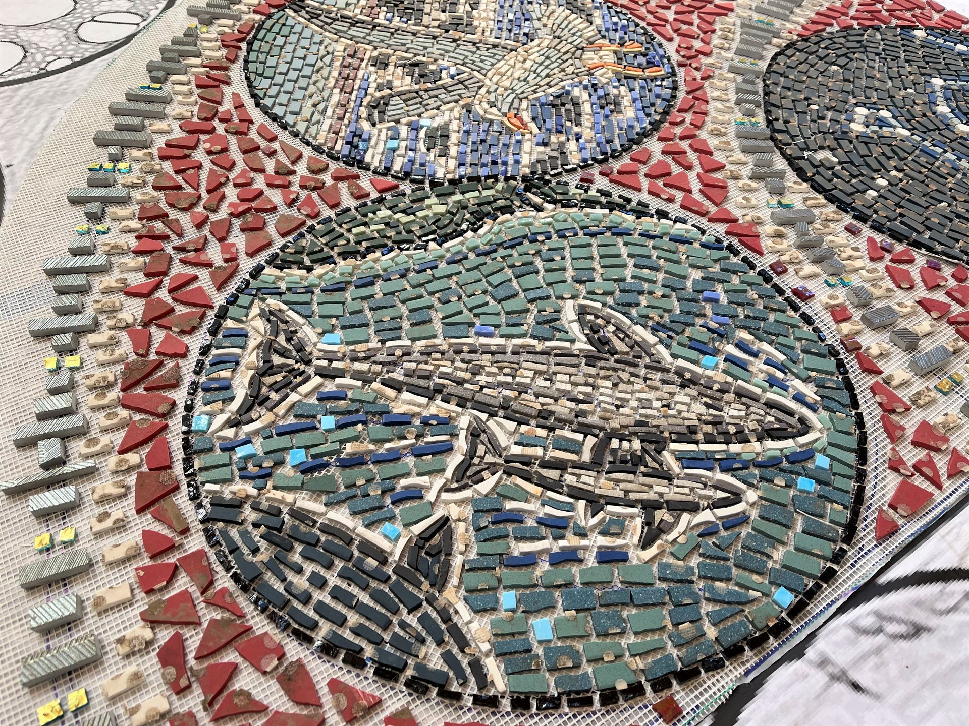 A close up of a mosaic of a shark in a circle.