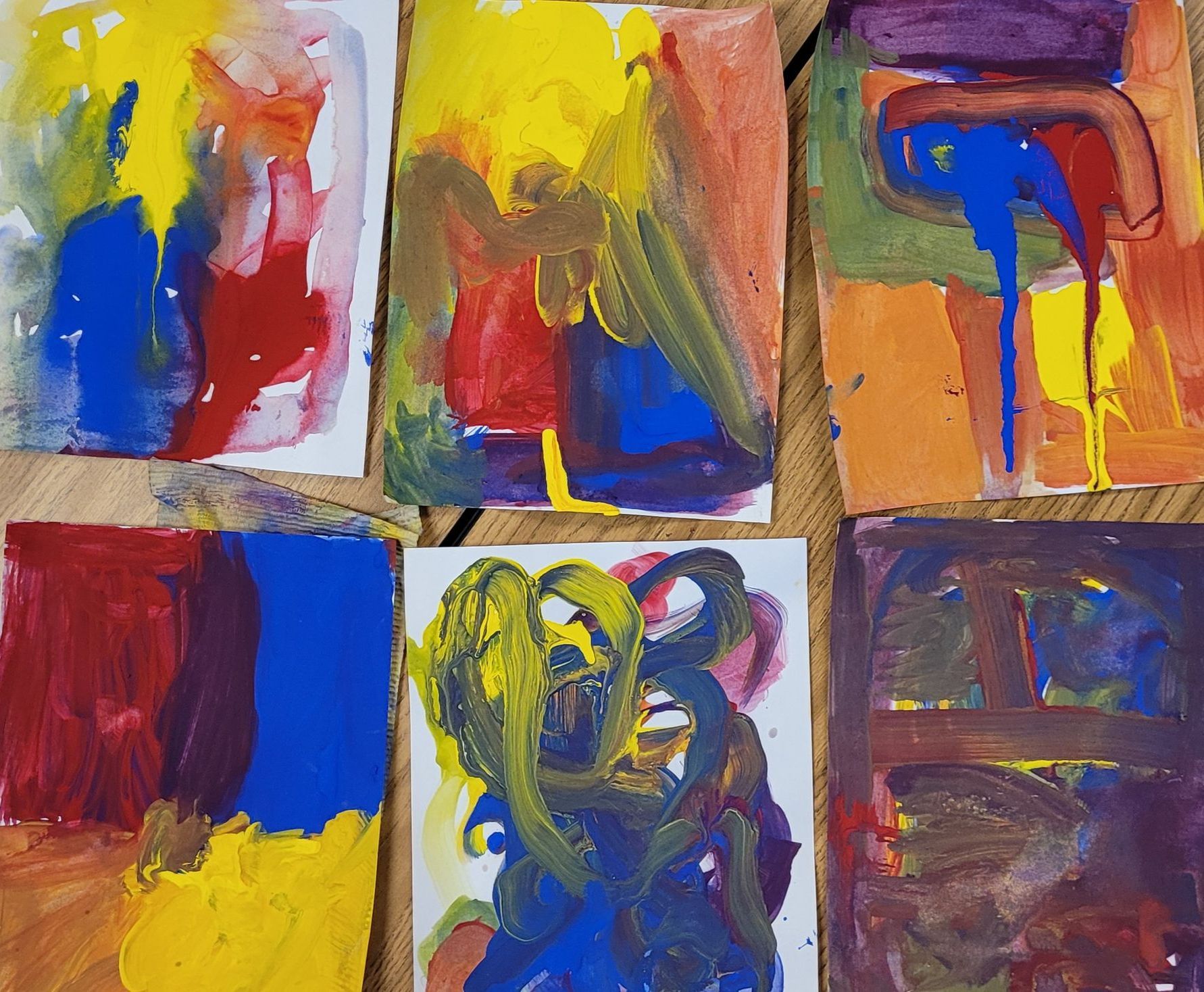 A bunch of colorful paintings on a table
