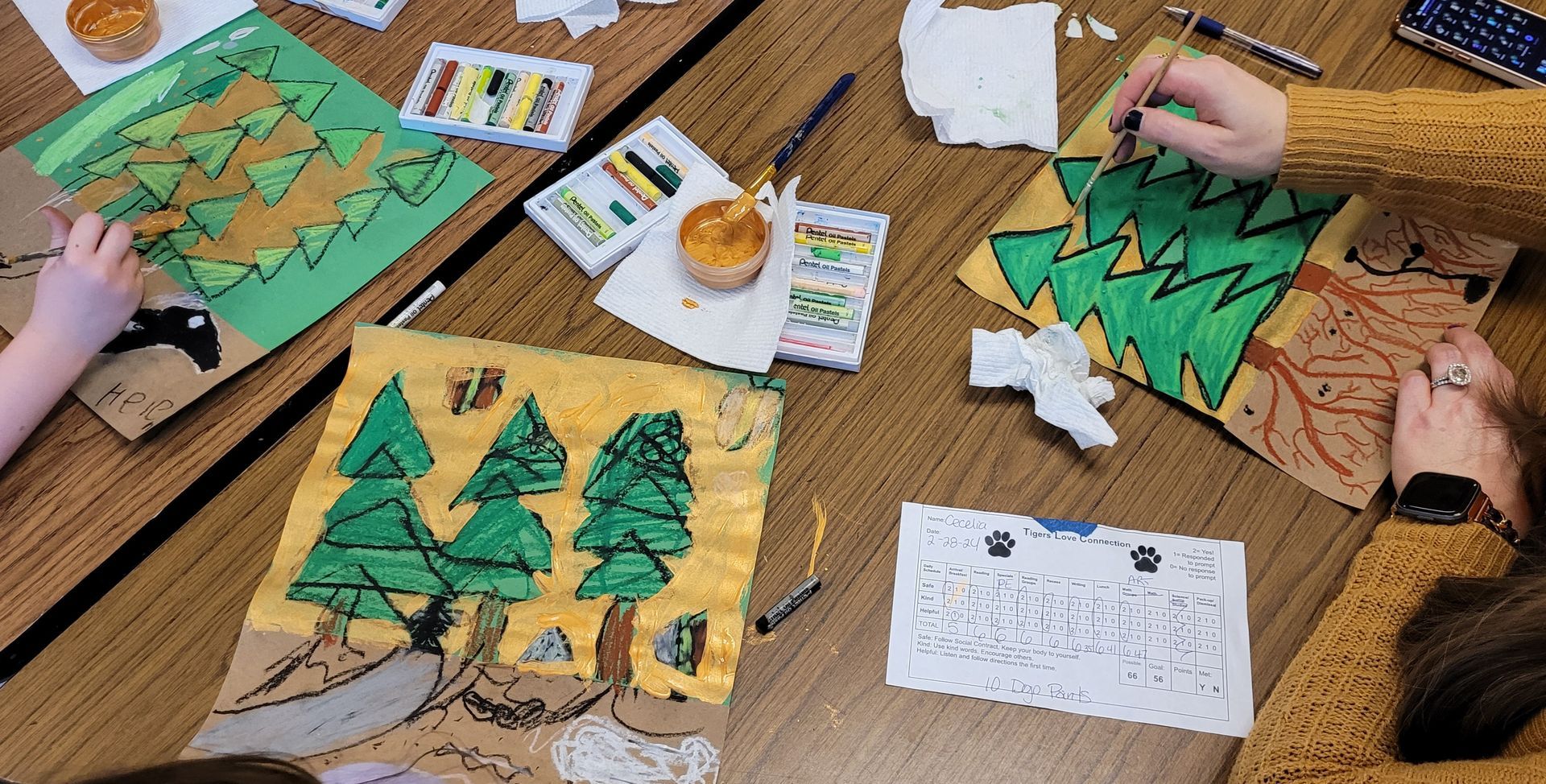 A group of people are sitting at a table making crafts.