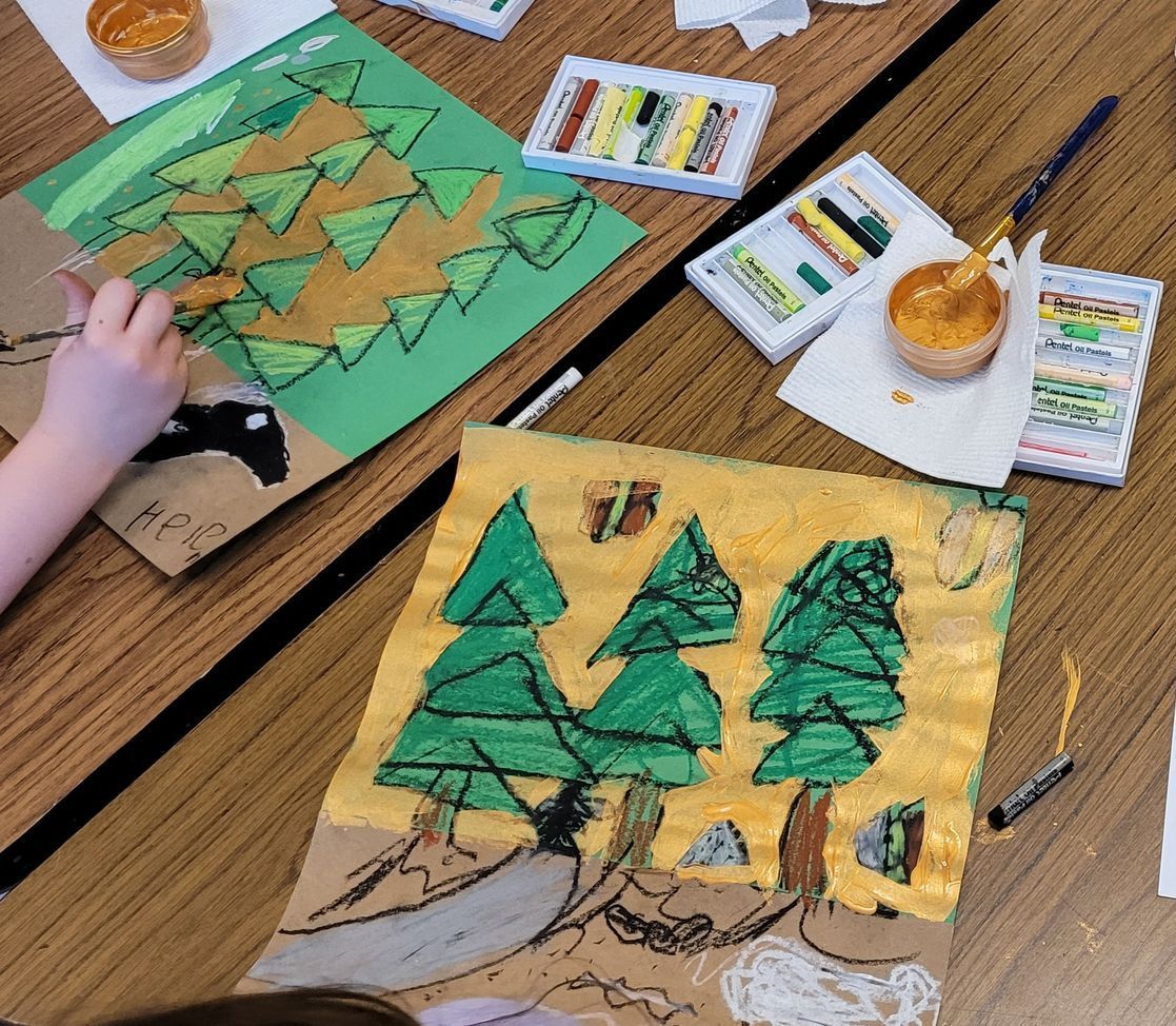 A child is painting a picture of trees on a table