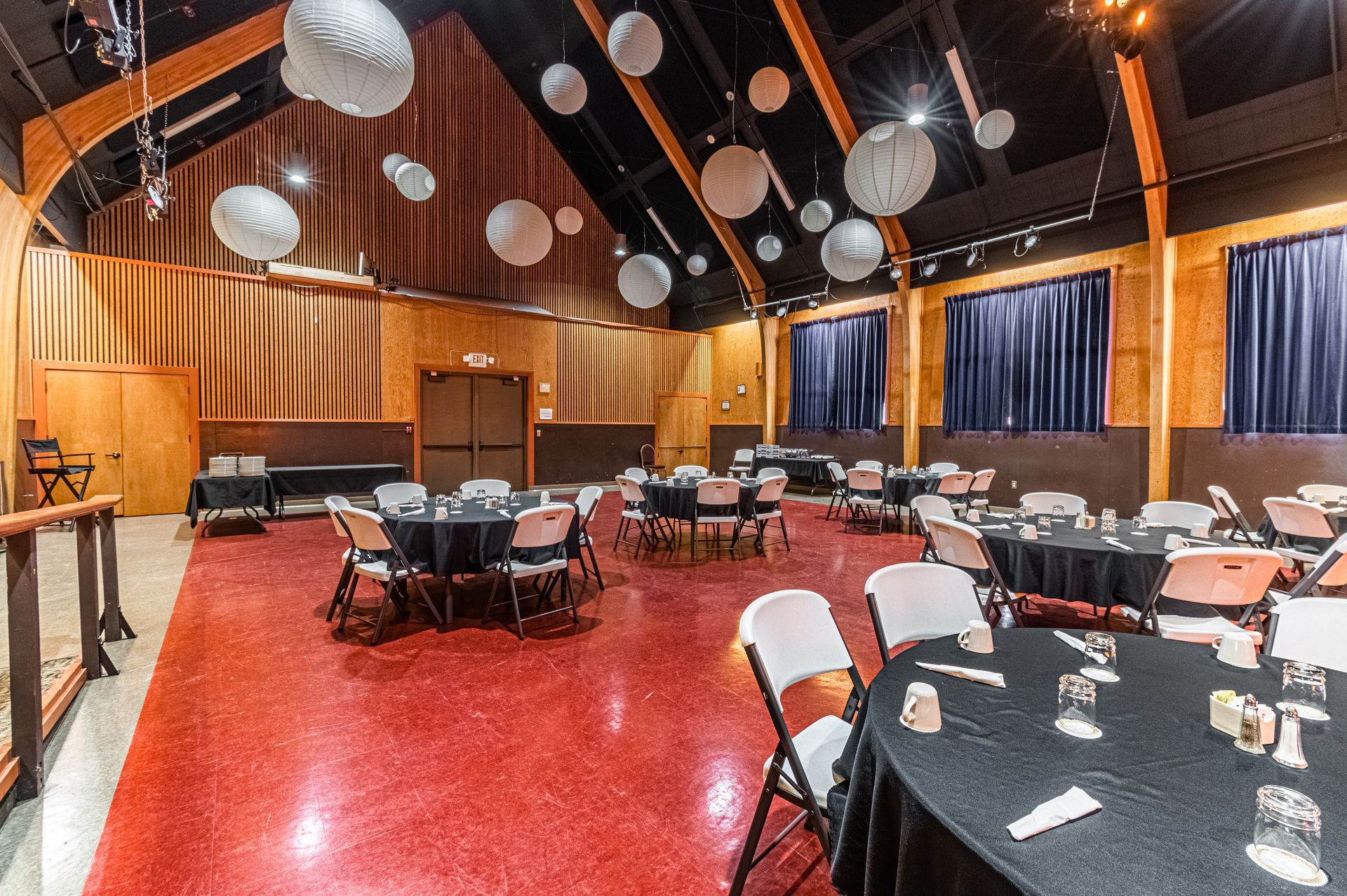 A large room with tables and chairs set up for a party.
