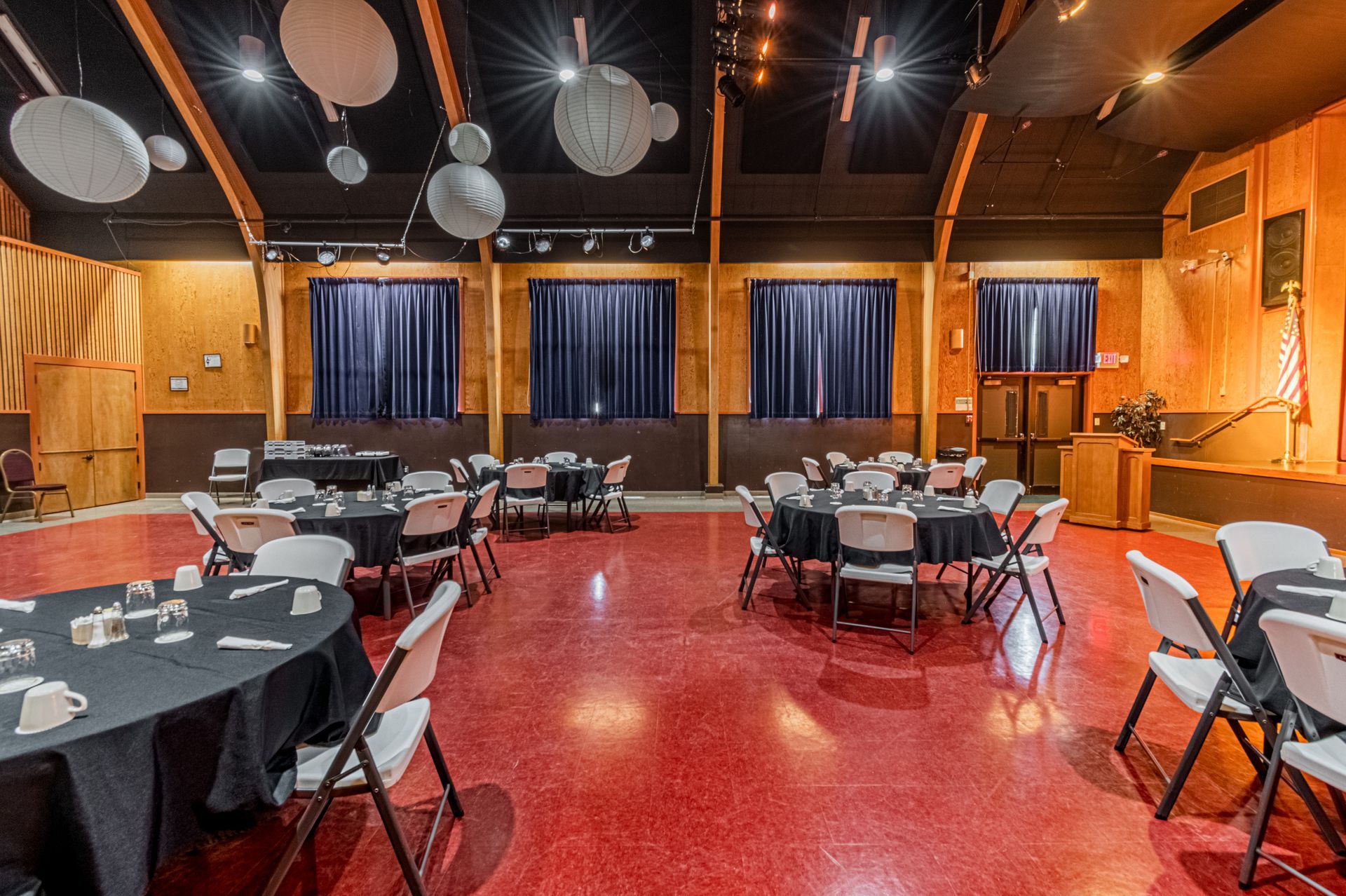 A large room with tables and chairs set up for a party.