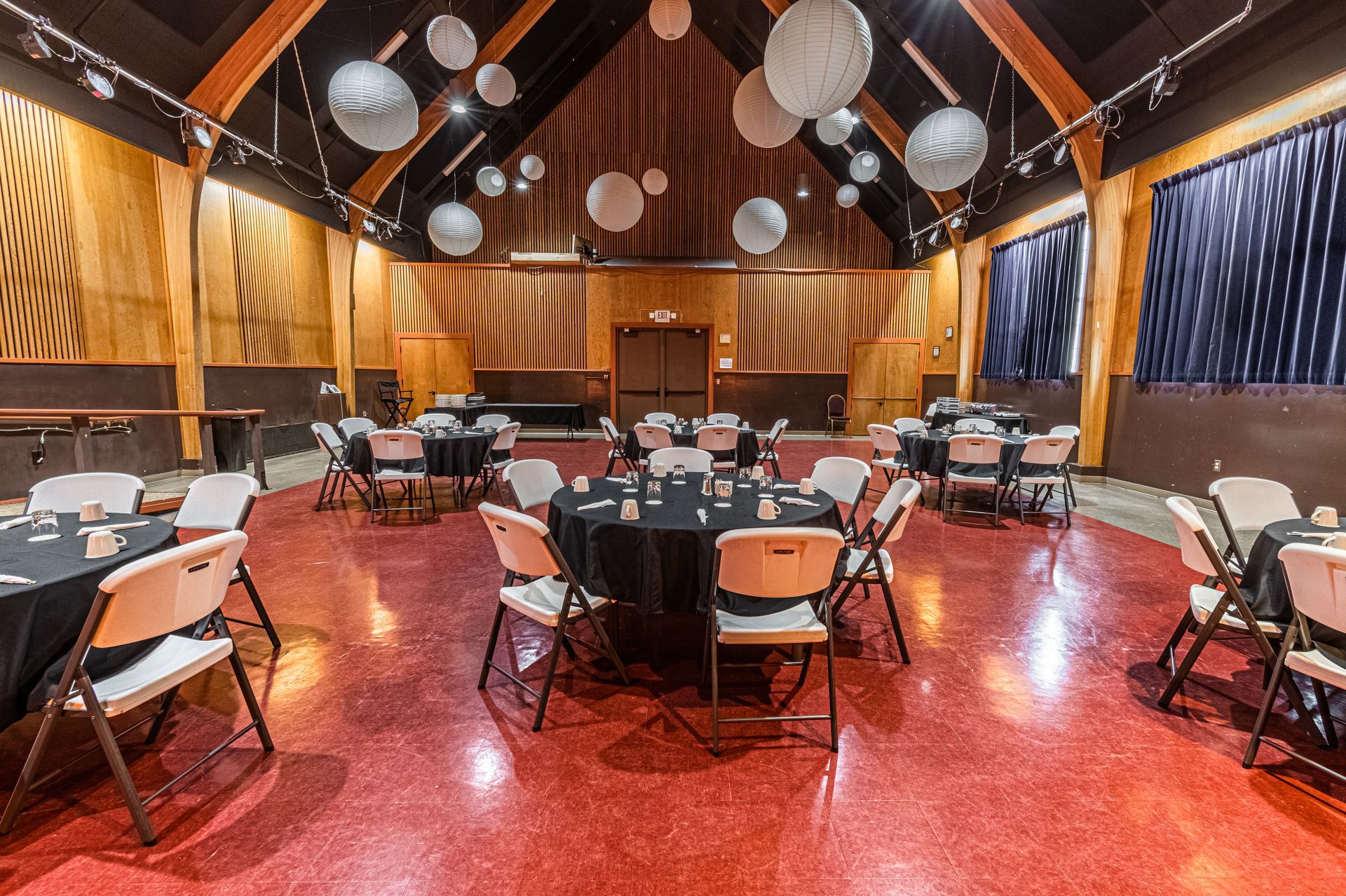 A large room with tables and chairs set up for a party.