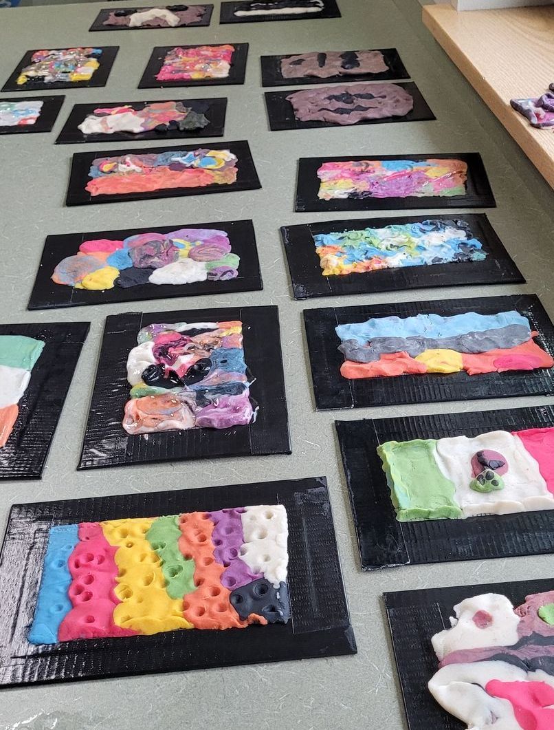 A bunch of colorful paintings are on the floor