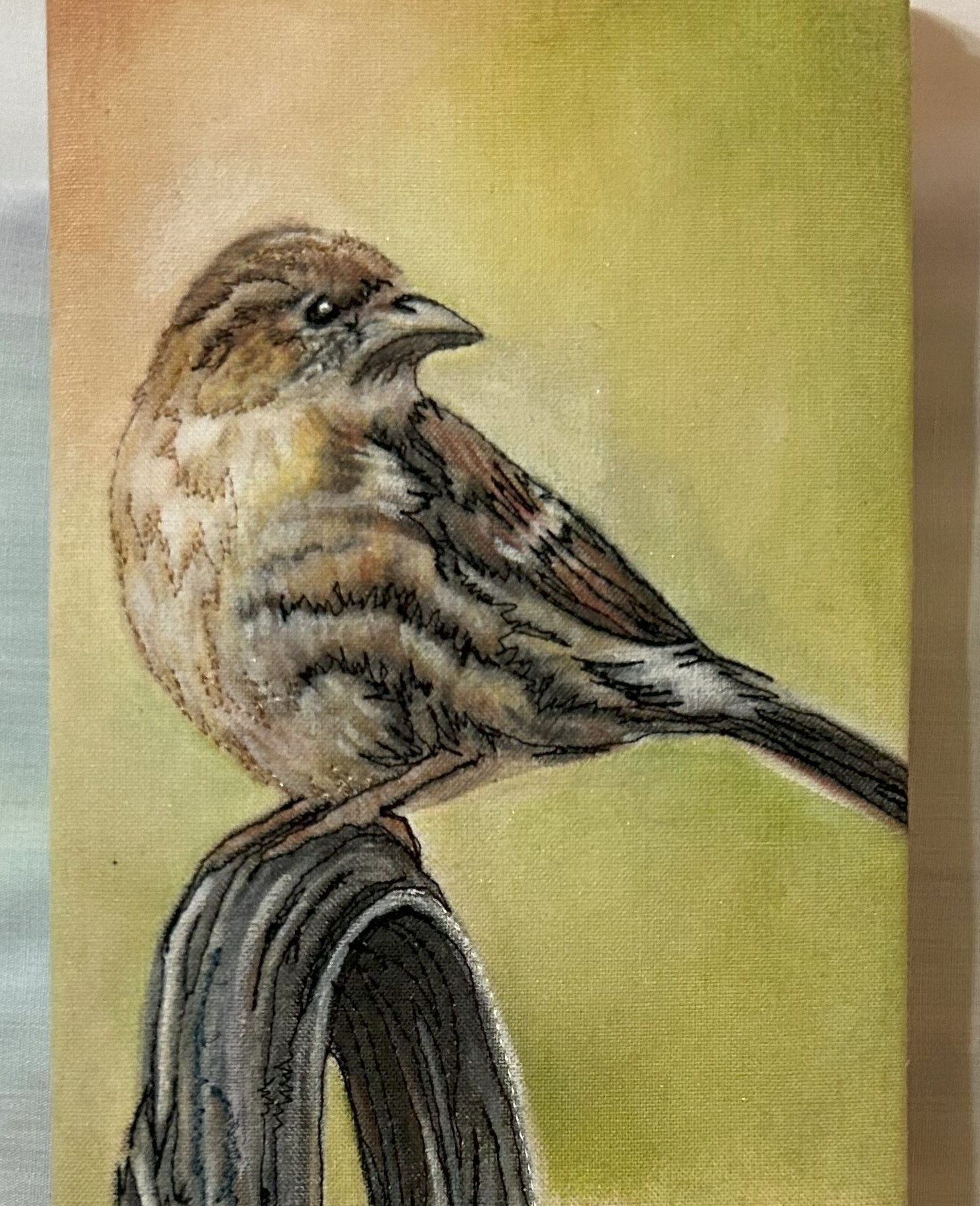 A small bird is perched on a branch in a painting.