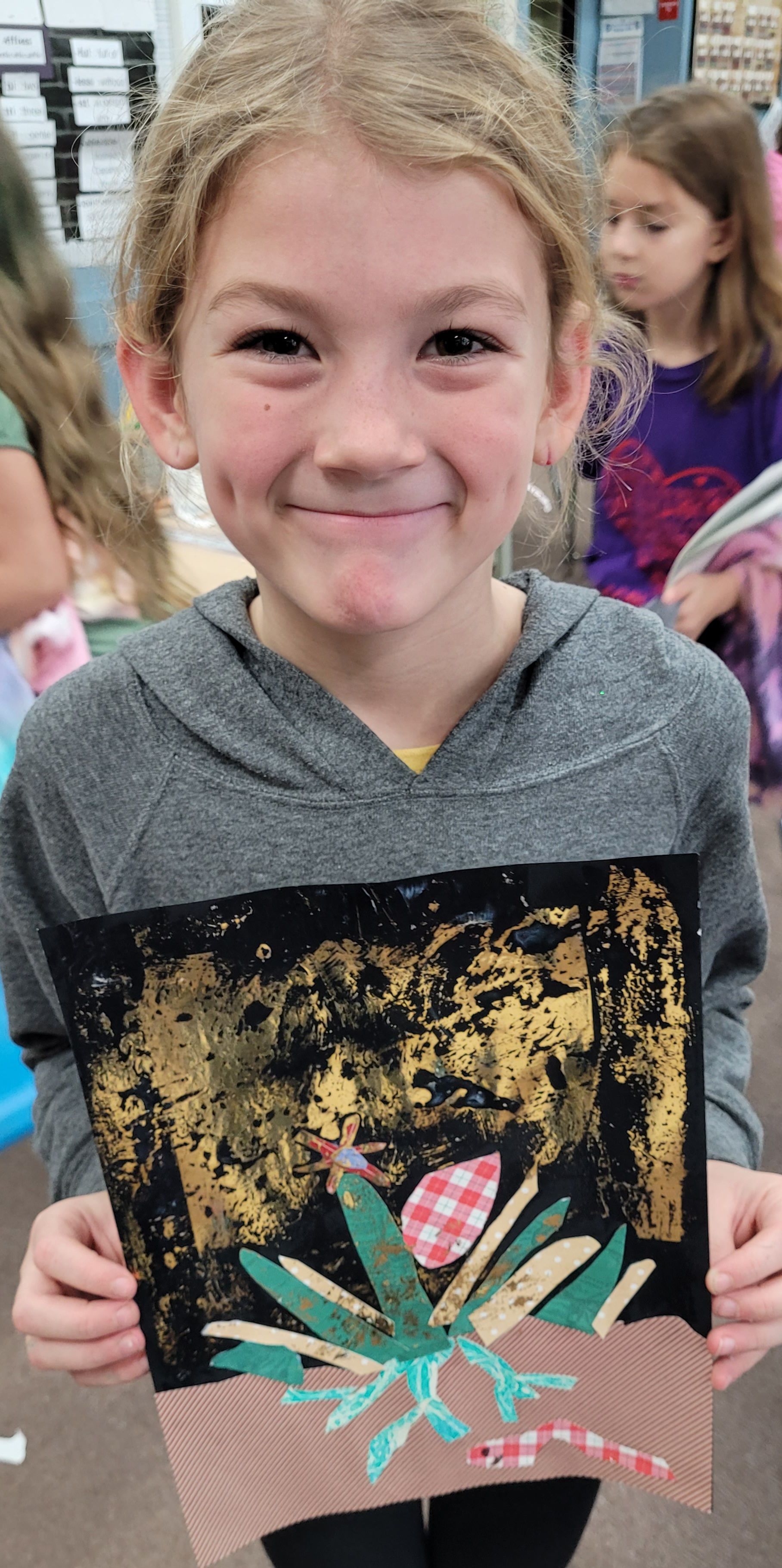 A young girl is holding a painting of a flower in her hands.