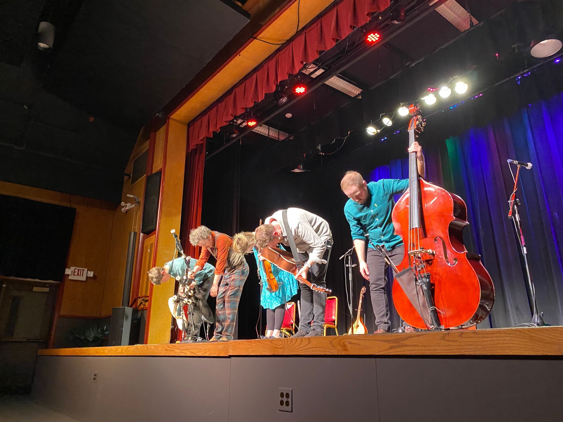 A group of people are standing on a stage playing instruments.