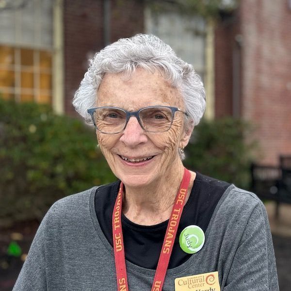 An older woman wearing glasses and a lanyard that says usc trojans