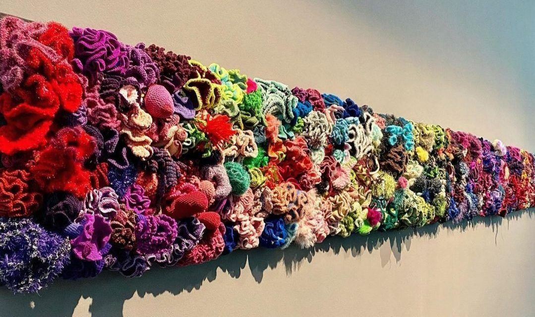 A bunch of colorful flowers are hanging on a wall