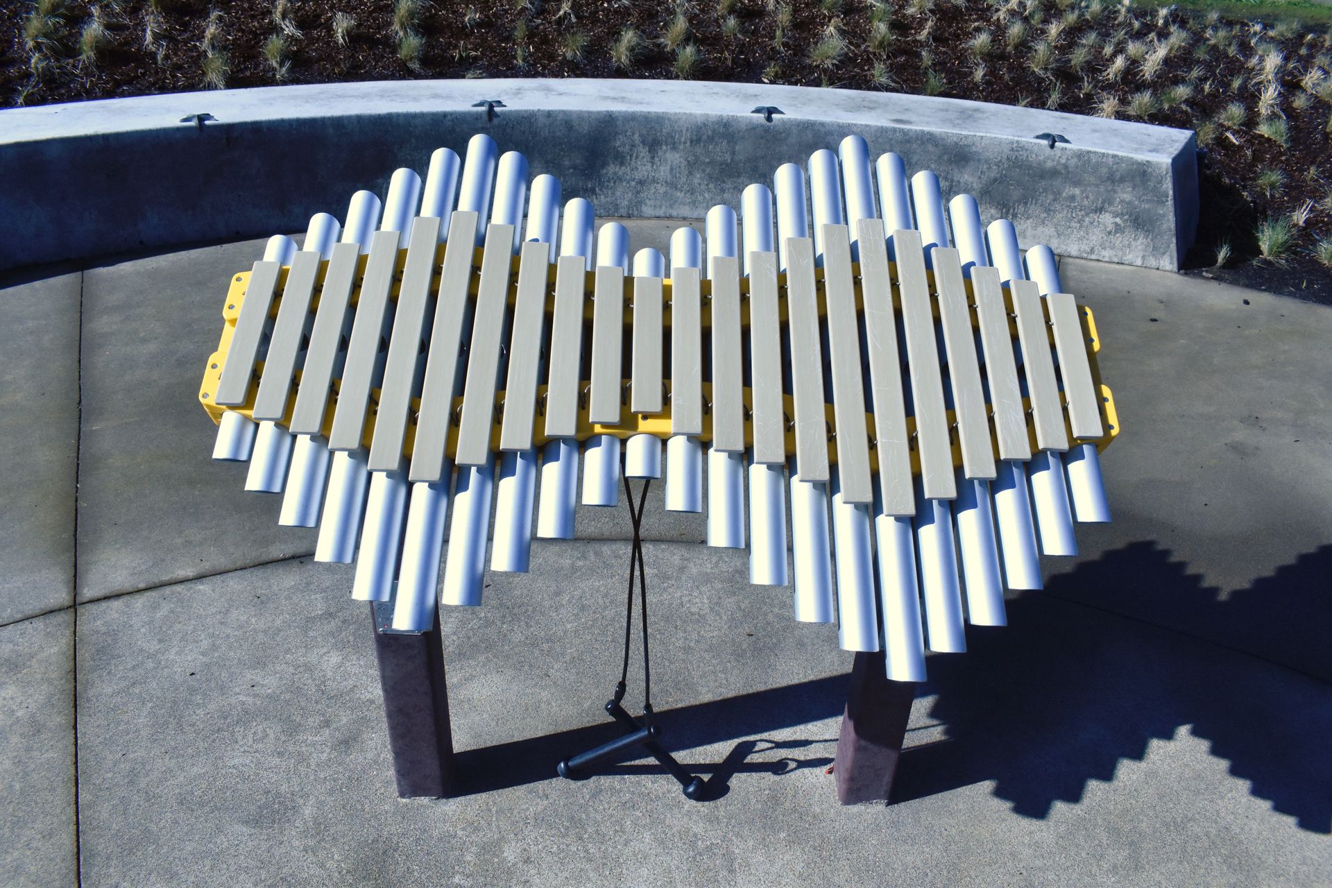 A heart shaped xylophone sits on a concrete surface