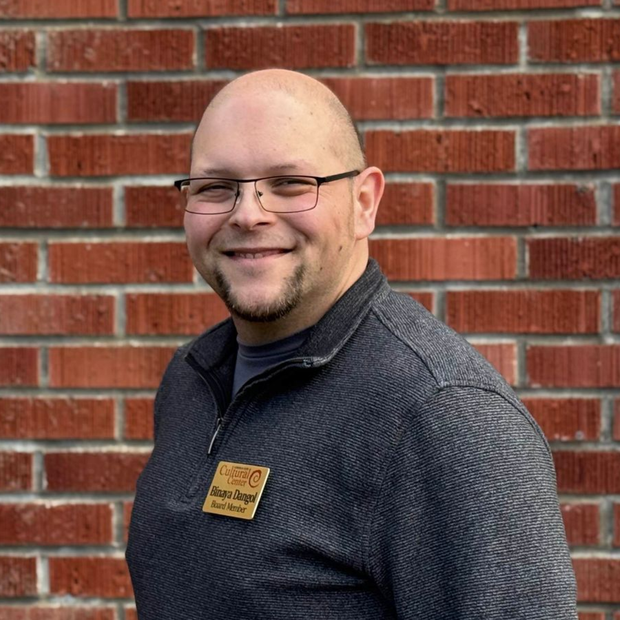 A man with glasses and a beard is smiling for the camera.