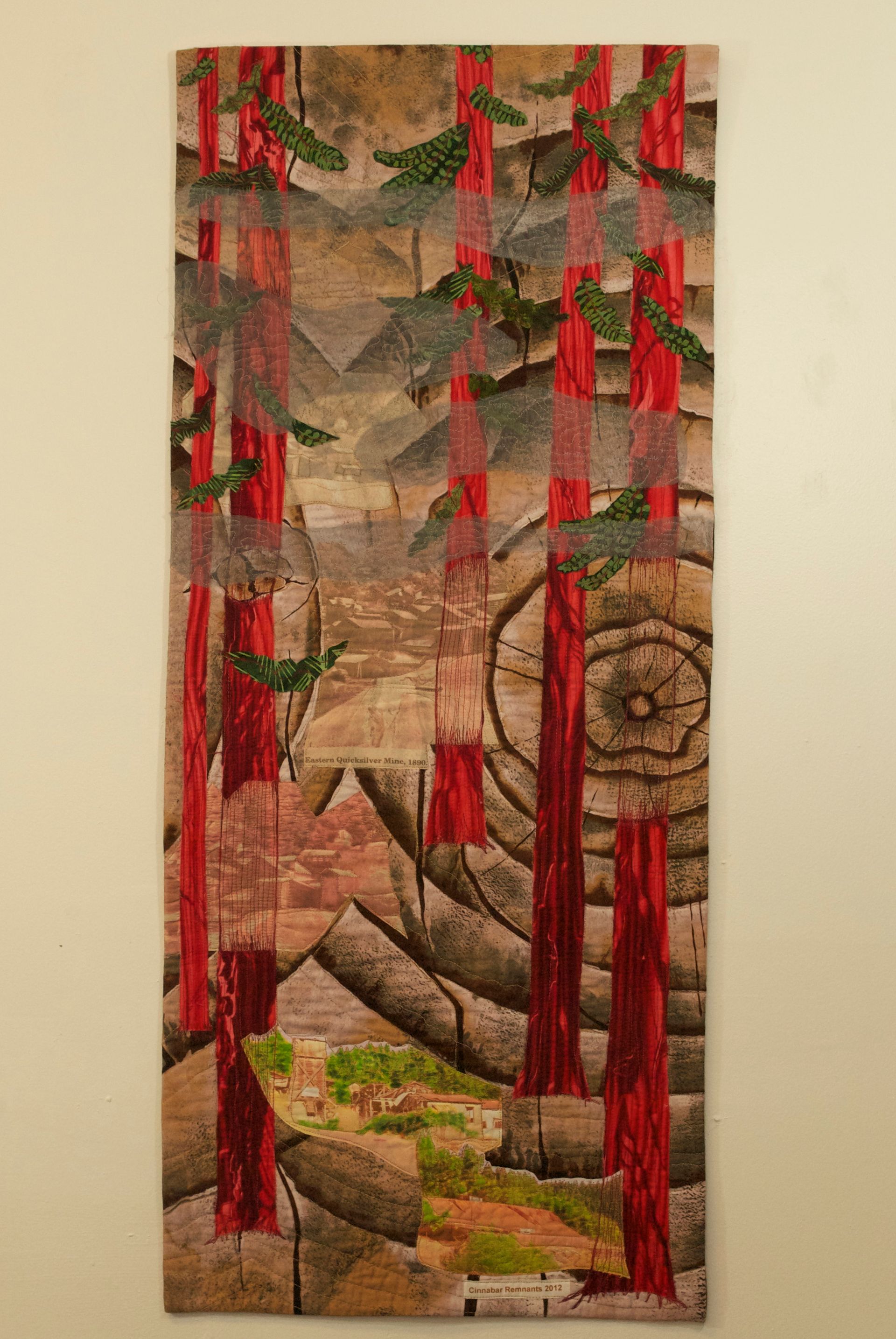 A painting of a forest with red trees is hanging on a wall.