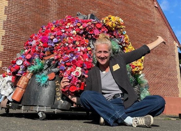 A woman is sitting in front of a large pile of flowers