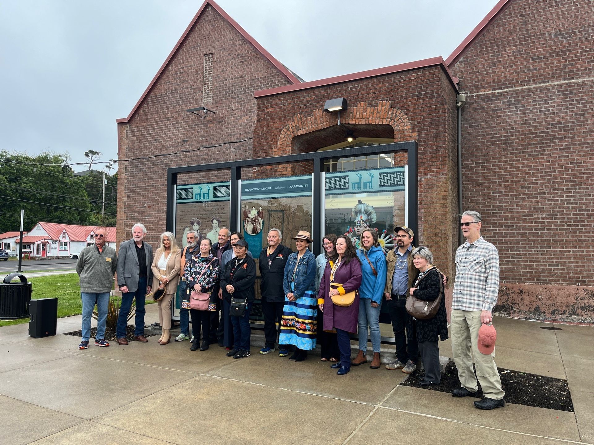 A group of people are standing in front of a brick building.