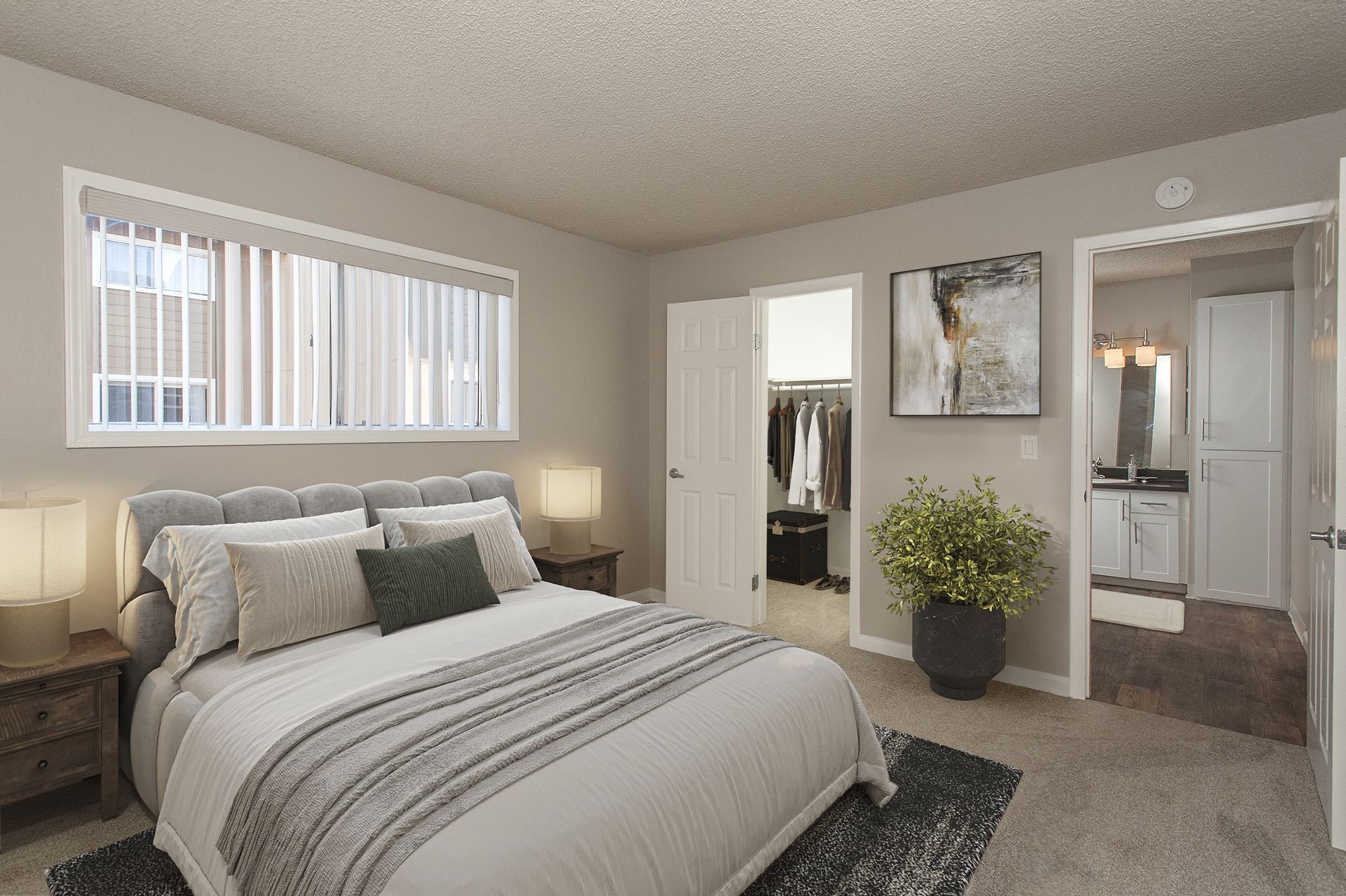 Bedroom in a modern apartment with a large bed, nightstands, and an open closet.
