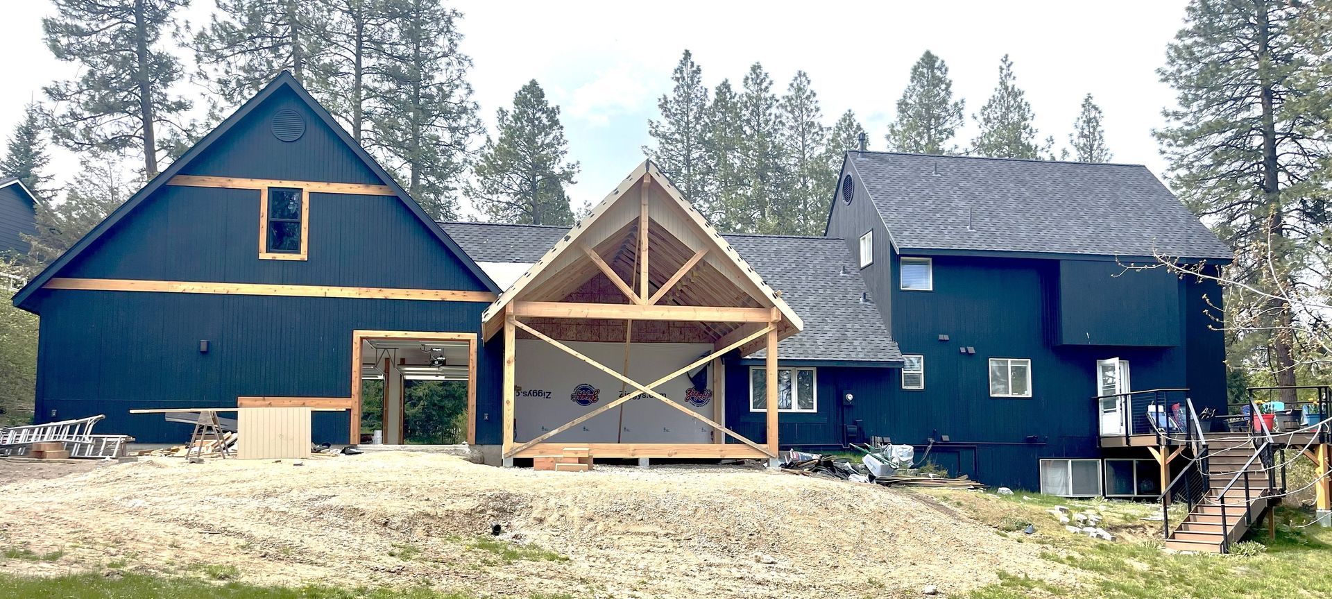 Construction site with wooden framing, lumber, and a partially built structure.