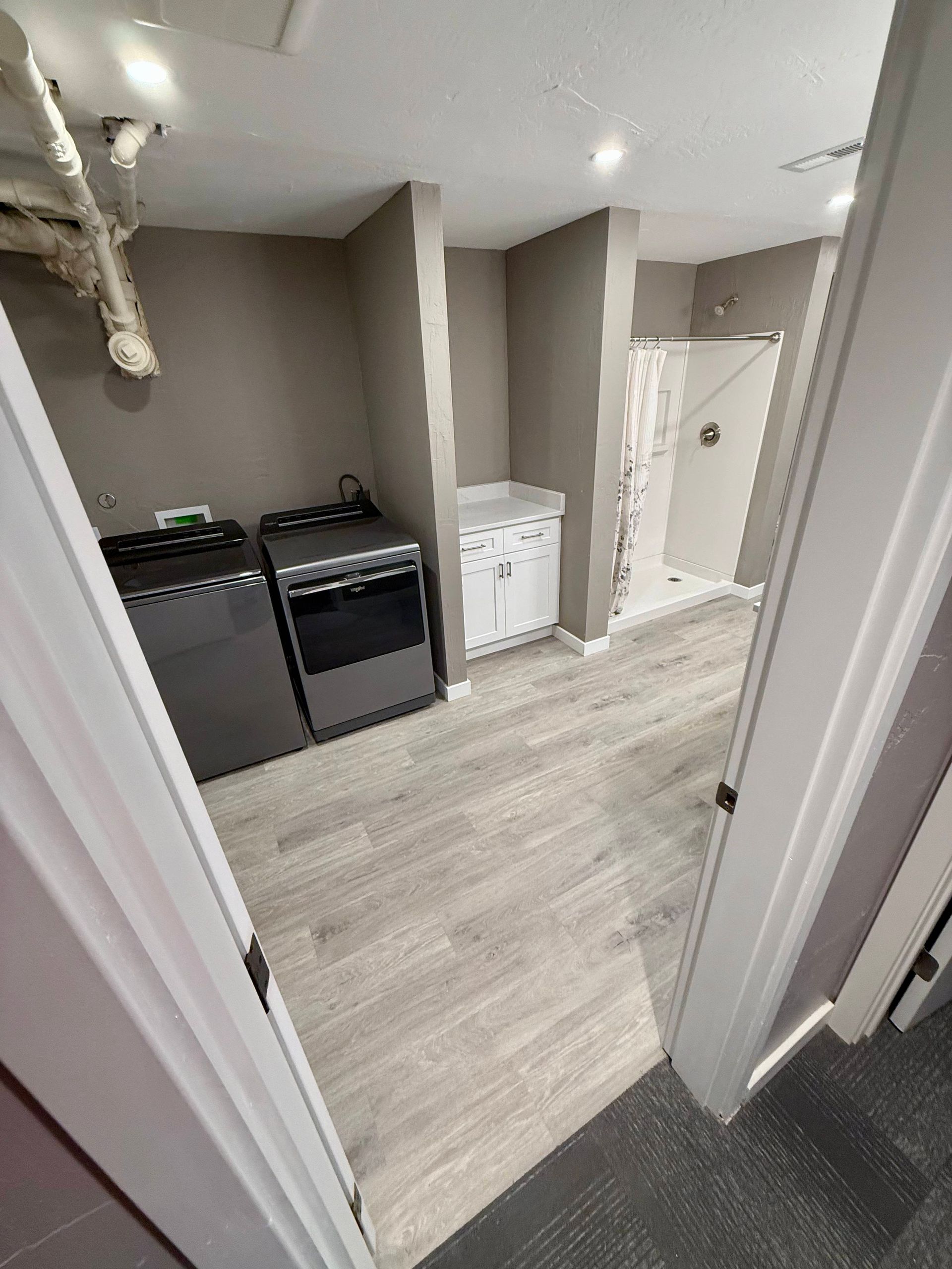 Empty dance studio with gray walls, large mirror, and recessed lighting.