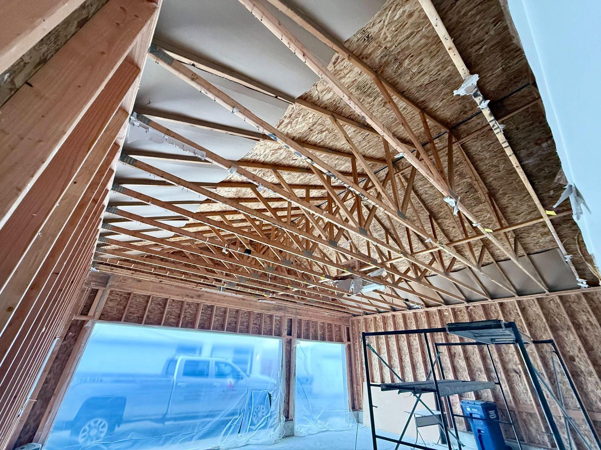 Blue two-story house with a porch, columns, and a gabled roof. Brown trim and red door.