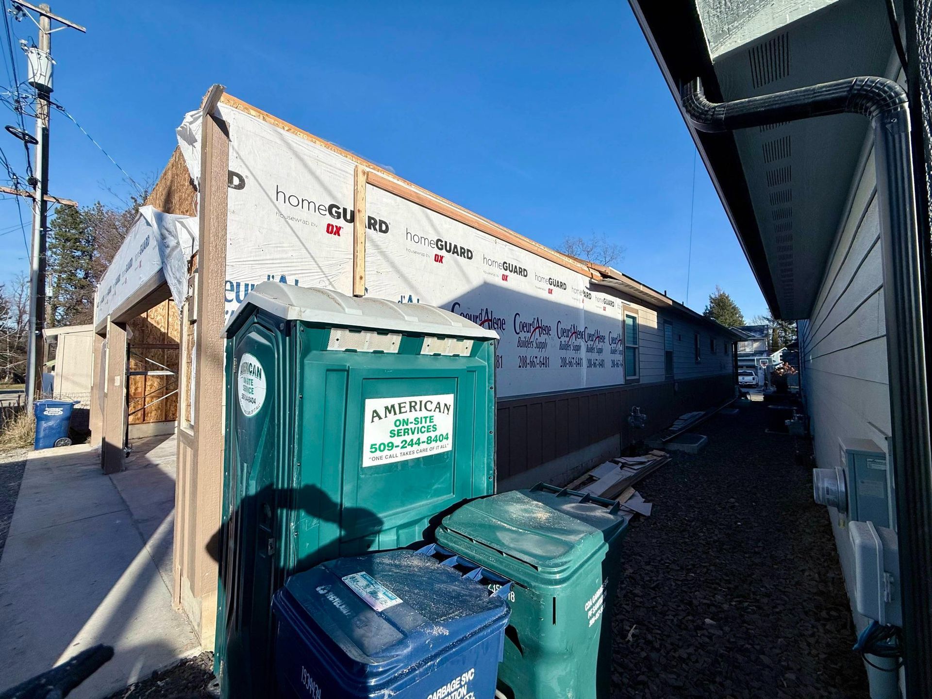 Construction site: Building with exposed framing, covered in white sheathing.