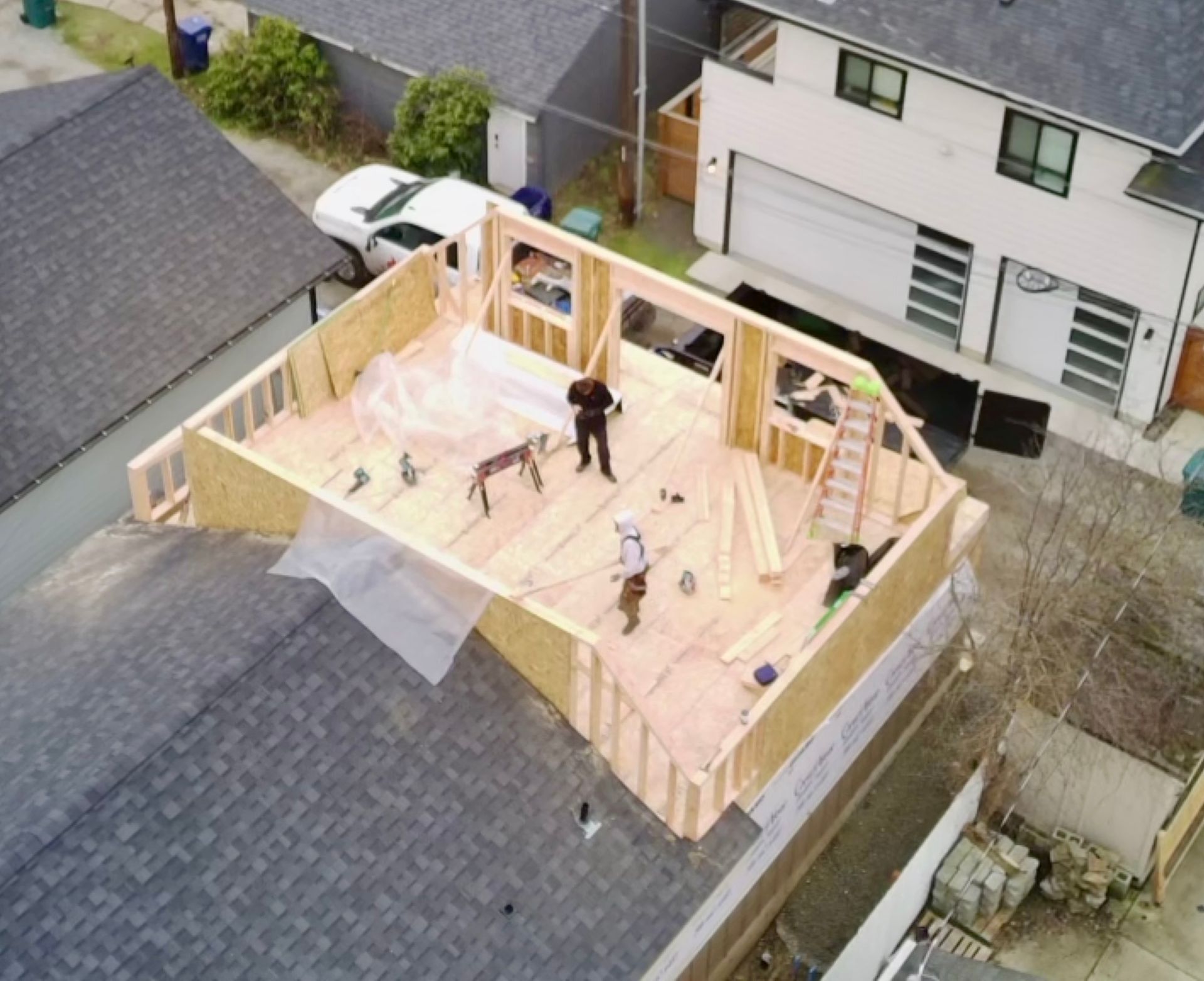 Construction site: workers building a second story addition on a house.