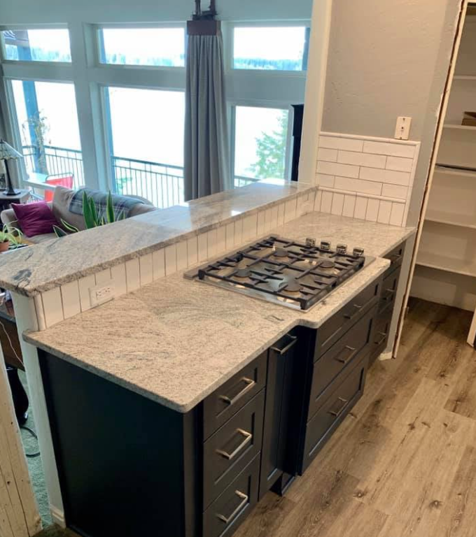 Kitchen with granite countertops, dark gray cabinets, and a gas stovetop.