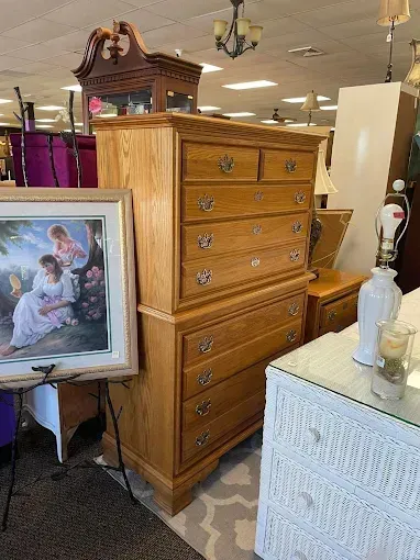 A room filled with furniture and a painting on a easel.