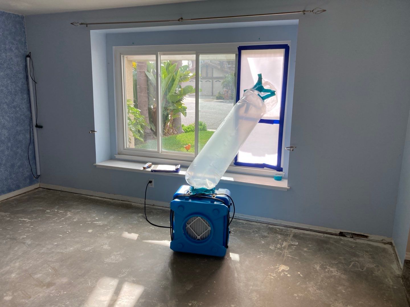A room with a window and a machine in front of it.