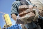 A worker carrying bricks