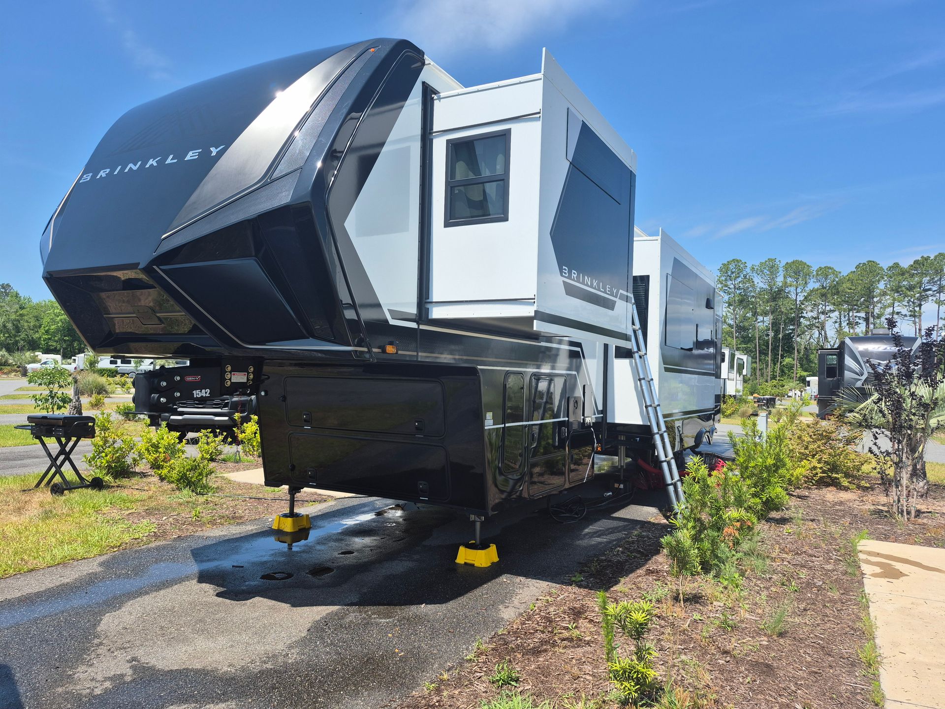 A black and white rv is parked in a parking lot.