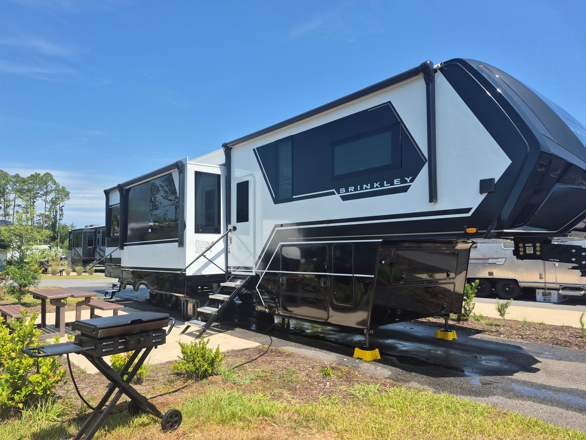 A large white and black rv is parked in a parking lot.
