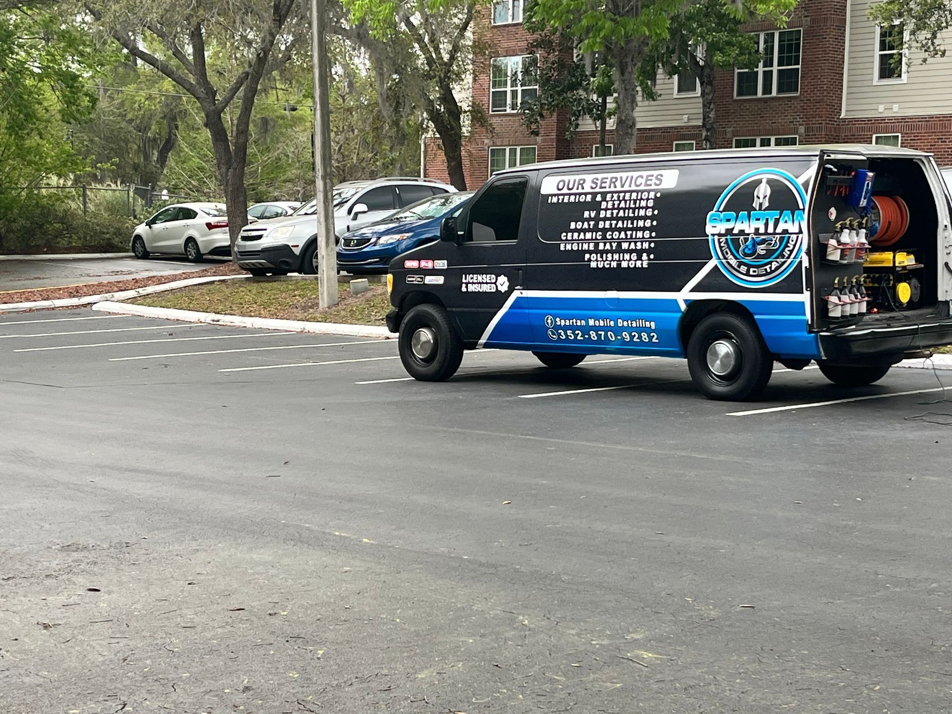 A black and blue van is parked on the side of the road.