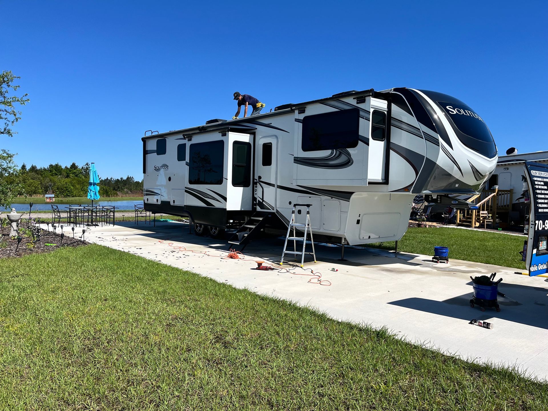 A man is working on the roof of a rv.