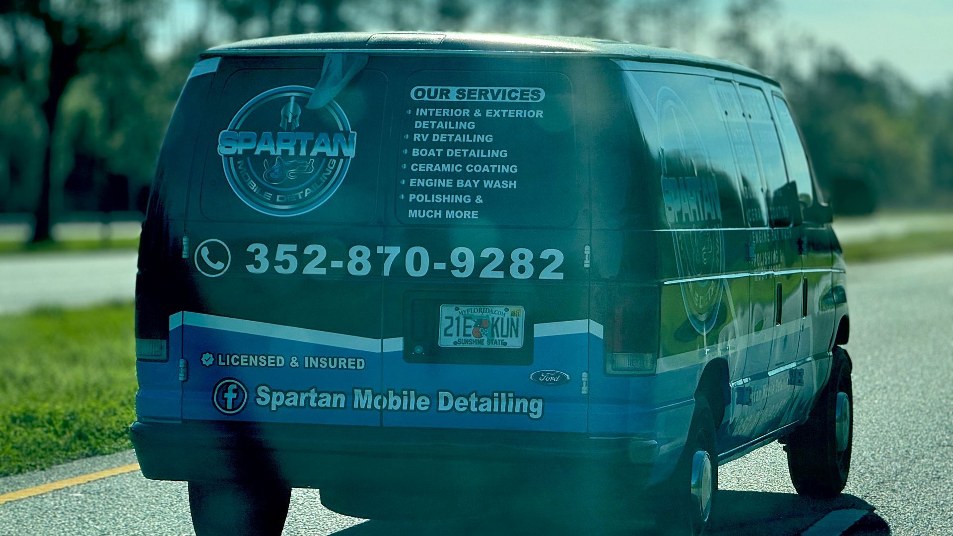 A black van is parked on the side of the road.