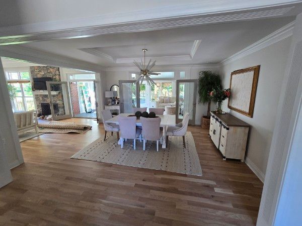 Dining room with a table, chairs, rug, sideboard, and outdoor view.