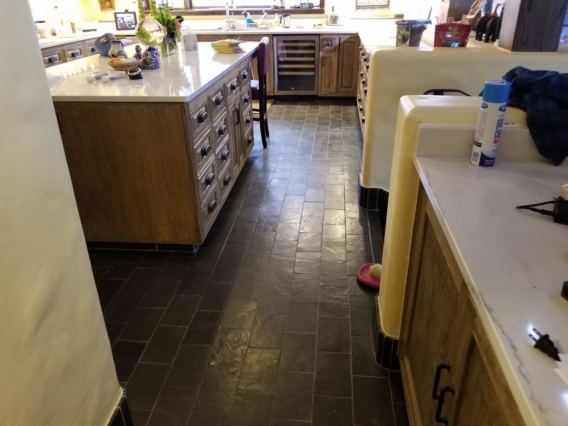 Kitchen with wood cabinets, white countertops, and dark tile floor.