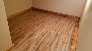 Small room with wood-look flooring and light-colored walls. Wooden trim lines the floor edges.