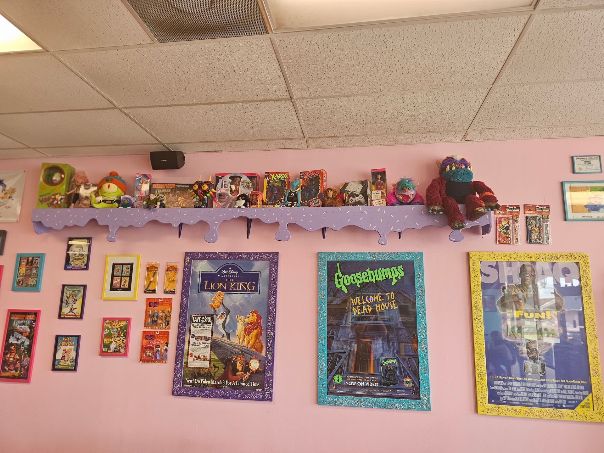 A pink wall with posters on it including one that says goosebumps