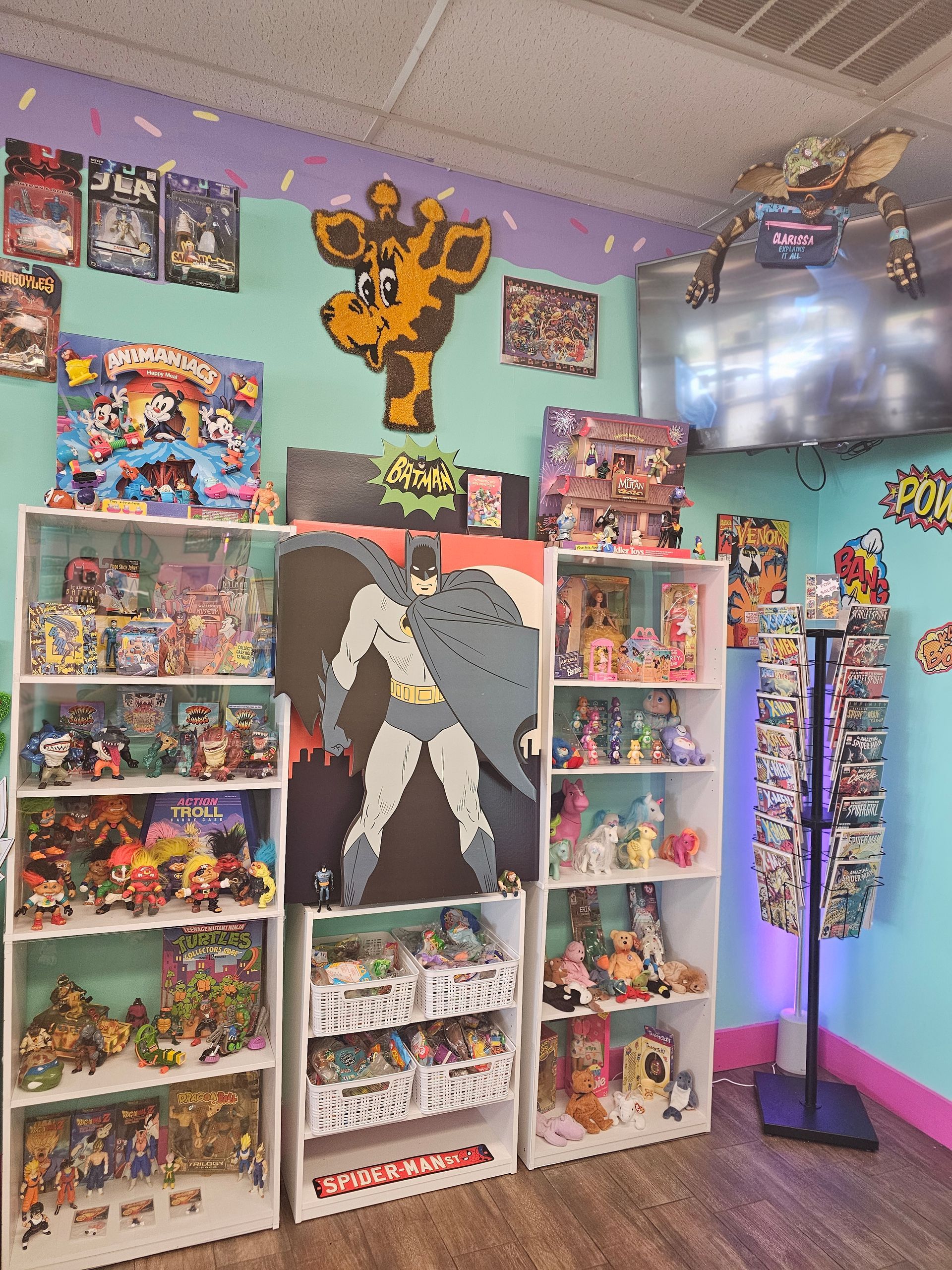 A room filled with lots of toys and a painting of batman