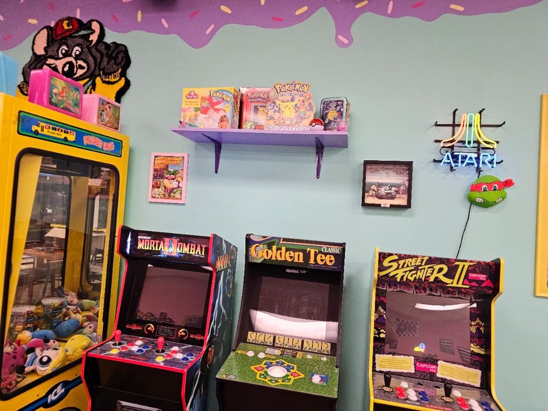 A row of arcade games including a blocking toe game